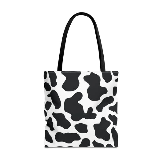 Large black and white cow print tote bag with black fabric handles for reusable shopping and travel use