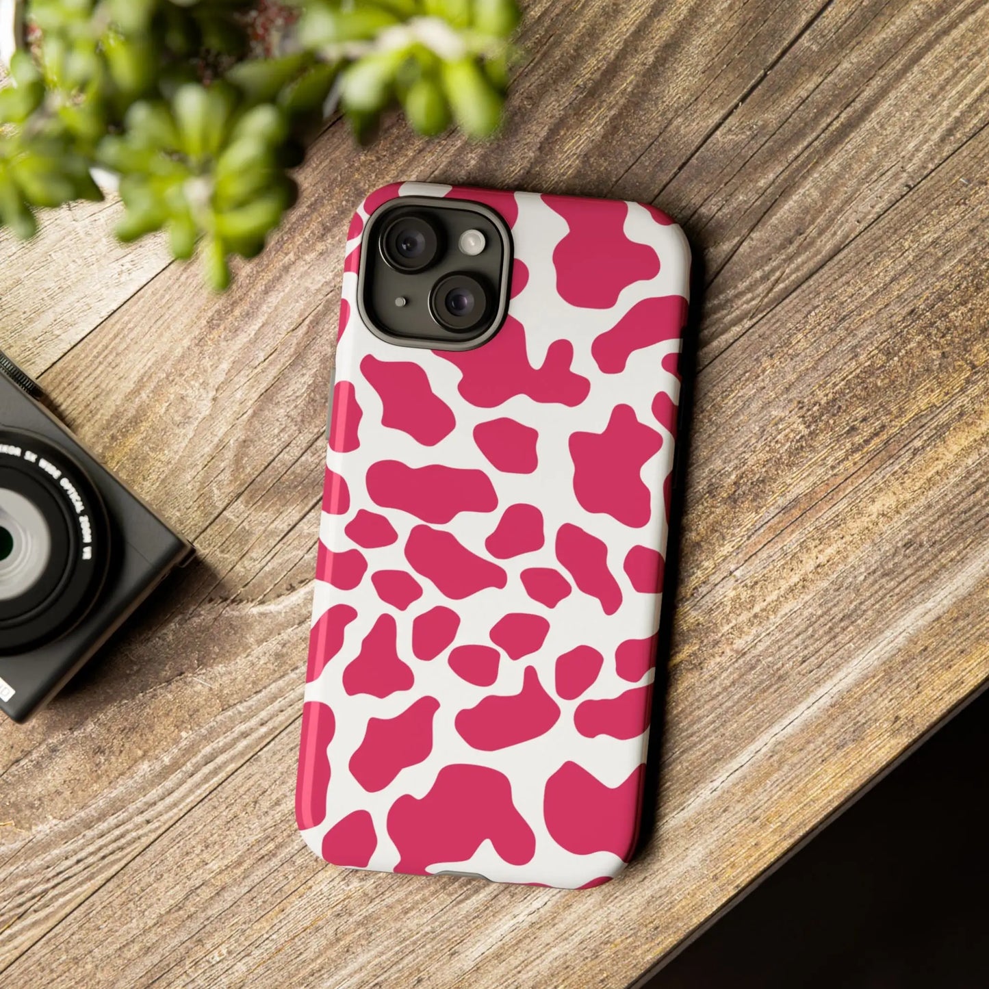 Back side of a vibrant pink cow print phone case cover with white spots and a smooth glossy finish for tough protection